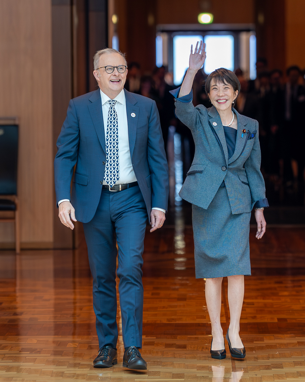 Prime Minister Anthony Albanese and Prime Minister of Japan Sanae Takaichi walk side-by-side through a formal building interior.