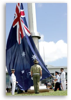 Australian flag being raised by defence personnel