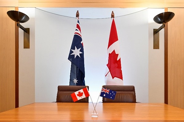 Two flagpoles in the background with a desk with two flags in the foreground.