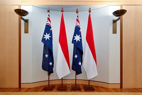 Four flagpoles of equal height in a row.