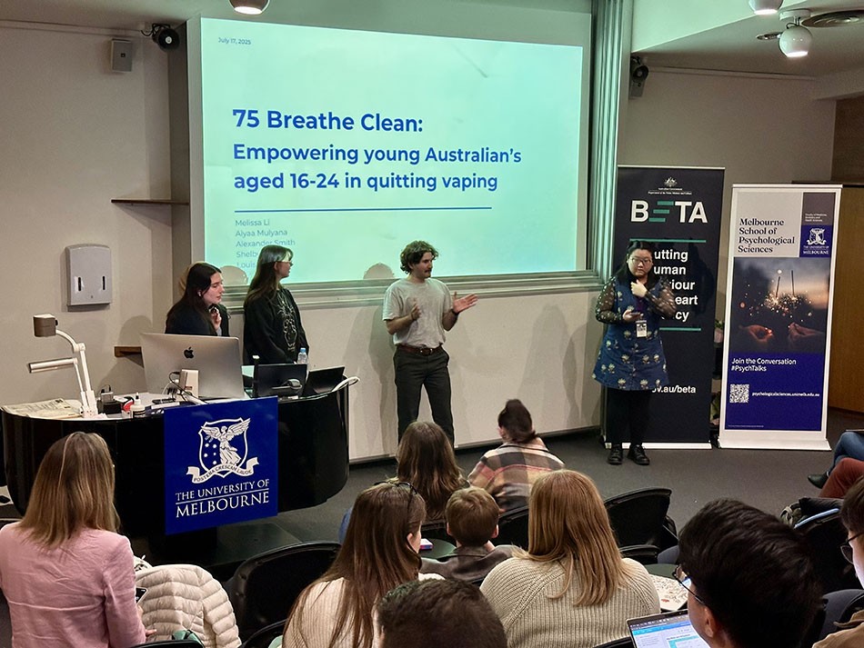  Four university students at the front of a lecture theatre presenting their winning pitch titled ‘75 Breathe Clean’.