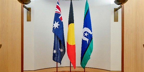 Three flagpoles of equal height in a row.