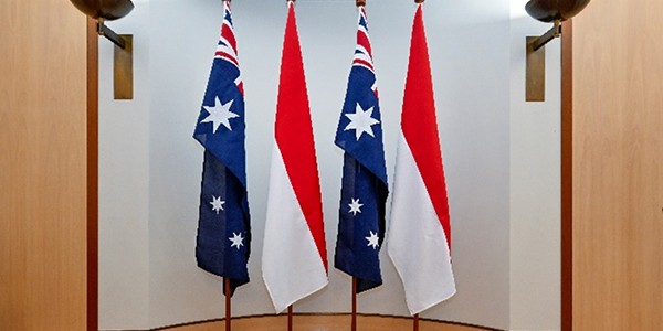 Four flagpoles of equal height in a row.