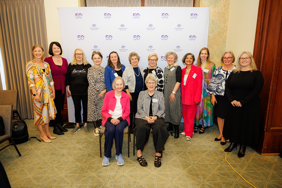 14 women pose for a group photograph while attending an event celebrating the Office for Women’s 50th anniversary.