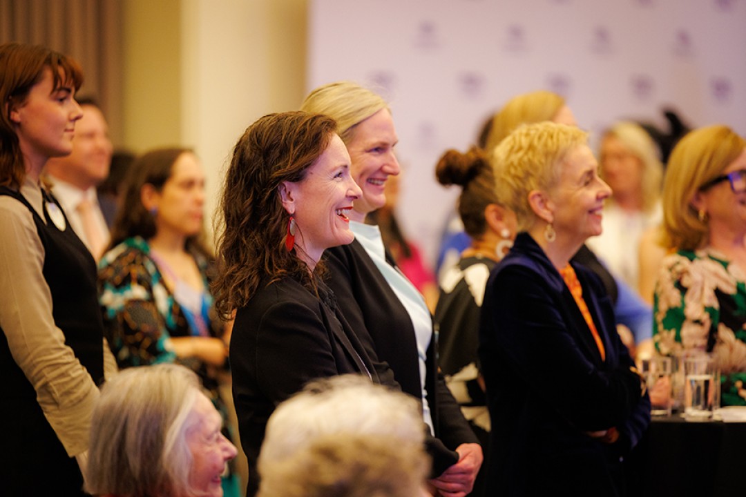 Tessa Boyd-Caine and Micaela Cronin listen to a speech being given at an event to mark the 50th anniversary of the Office for Women.