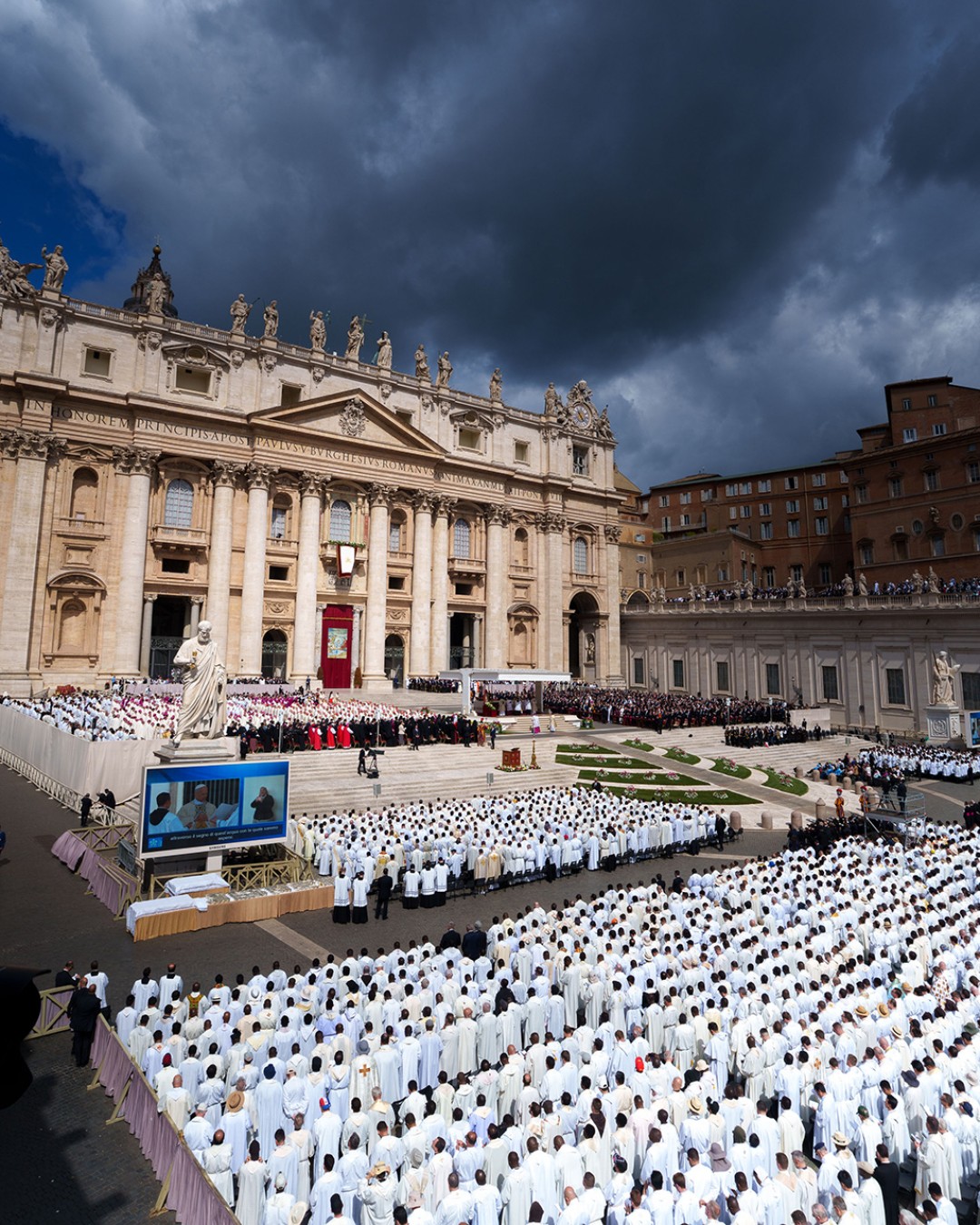 Inauguration Mass of His Holiness Pope Leo XIV at Saint Peter’s Square, rows of seats filled with worshippers in white face a stage.