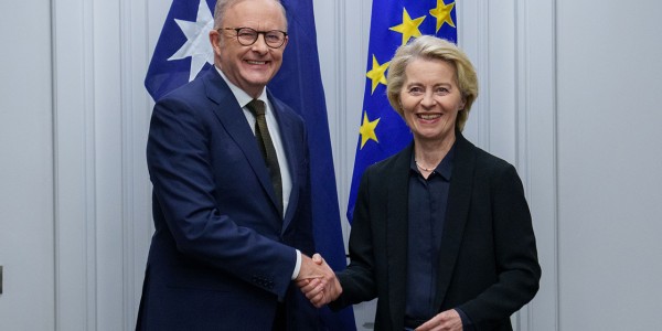 Prime Minister Anthony Albanese met with EU Commission President Ursula von der Leyen while in Rome, Italy. They shake hands in front of the flags of Australia and the European Union.