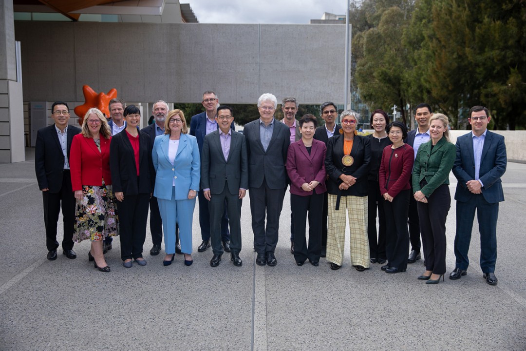 Professor Glyn Davis AC stands in the centre with APS leaders and a delegation from Singapore, all smiling at the camera.