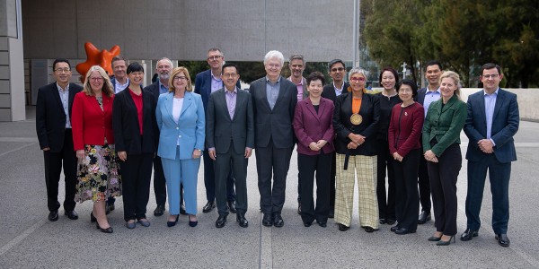 Professor Glyn Davis AC stands in the centre with APS leaders and a delegation from Singapore, all smiling at the camera.
