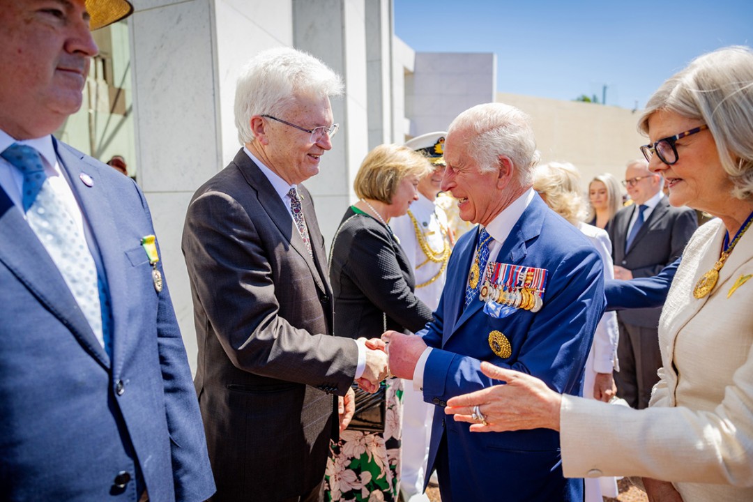 Professor Glyn Davis AC shaking hands with His Majesty King Charles III, while the Governor-General of Australia, Samantha Joy Mostyn AC, extends her hand to shake hands with another person. Other persons including Prime Minister Anthony Albanese are lined up to shake hands with people.