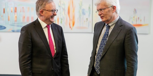 Prime Minister Anthony Albanese smiling at Professor Glyn Davis AC, in discussion.