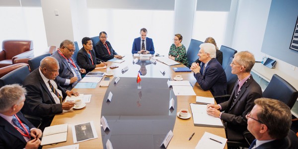 Professor Glyn Davis AC seated at a round table discussion with 10 PNG-AUS secretaries.
