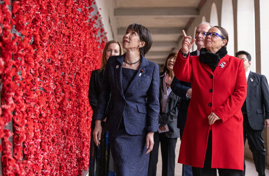 Prime Minister of Japan Sanae Takaichi view a wall of red poppies during a commemorative visit.