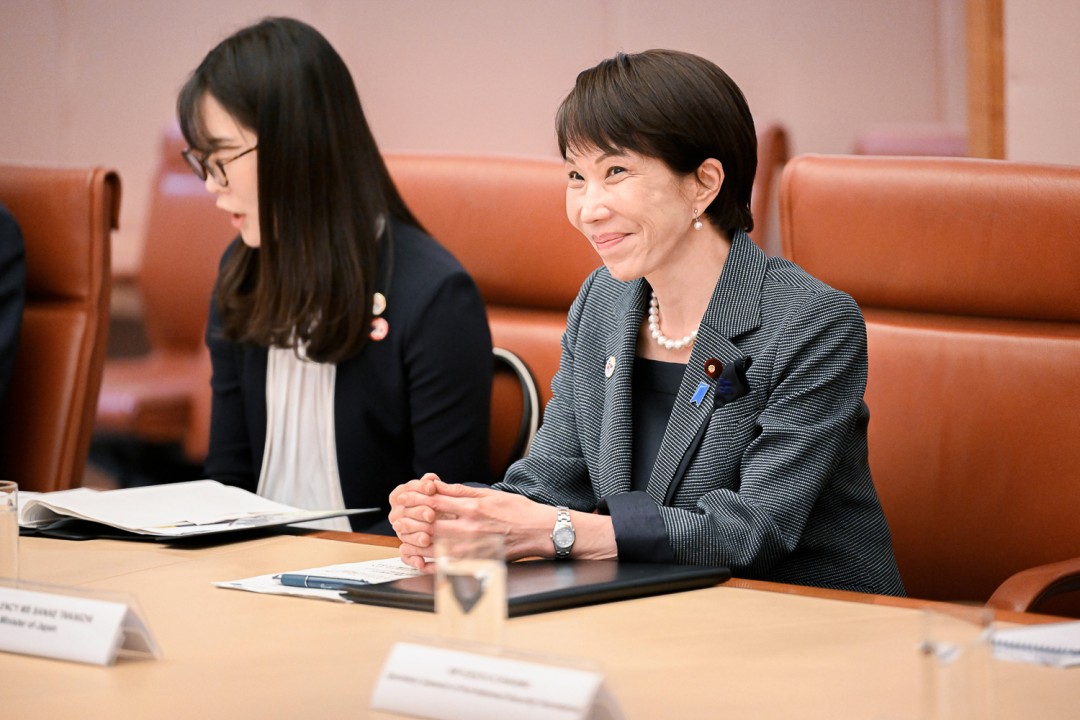 Prime Minister of Japan Sanae Takaichi participates in a meeting at a conference table.