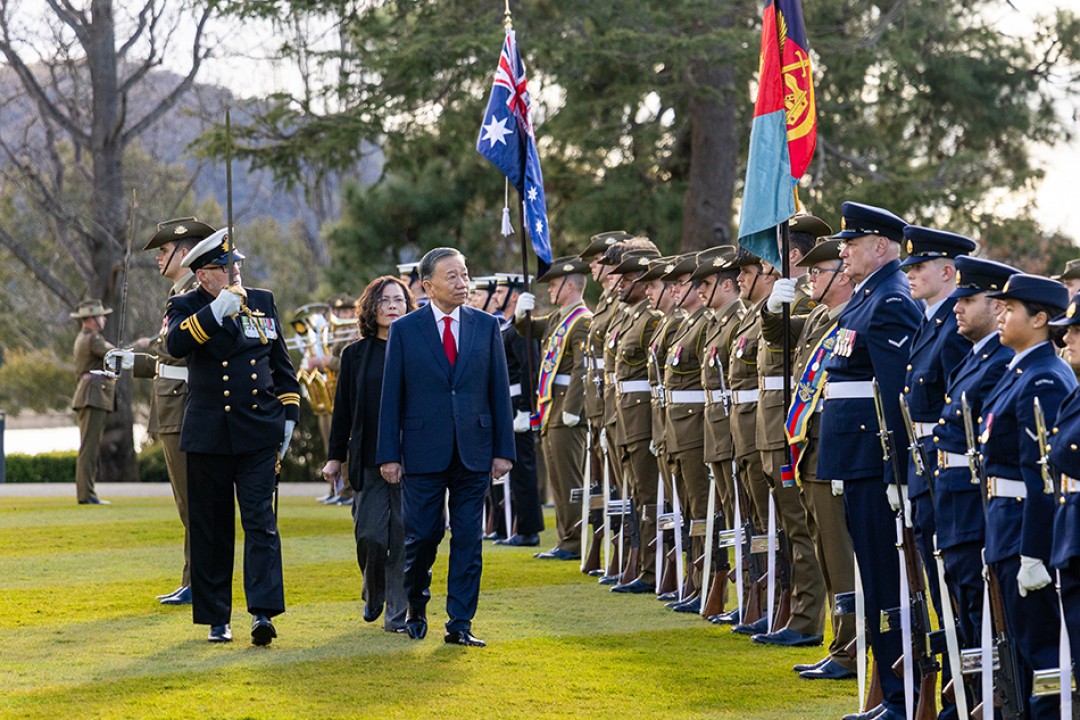 Her Excellency the Honourable Ms Sam Mostyn AC, Governor-General of the Commonwealth of Australia, and General Secretary and President of the Socialist Republic of Vietnam To Lam walk past a ceremonial guard of honour during the Welcome Ceremony at Government House, with Australian and Vietnamese flags visible.