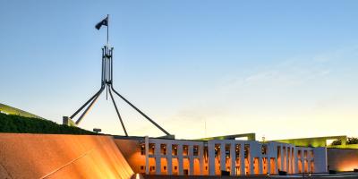 Flag and front building facade of Parliament House in Canberra