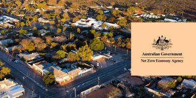 Australian Government Net Zero Economy Agency logo over a photo featuring a country town with a cross road in the foreground.