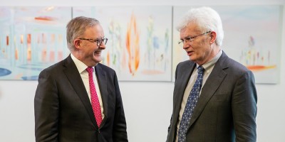 Prime Minister Anthony Albanese smiling at Professor Glyn Davis AC, in discussion.